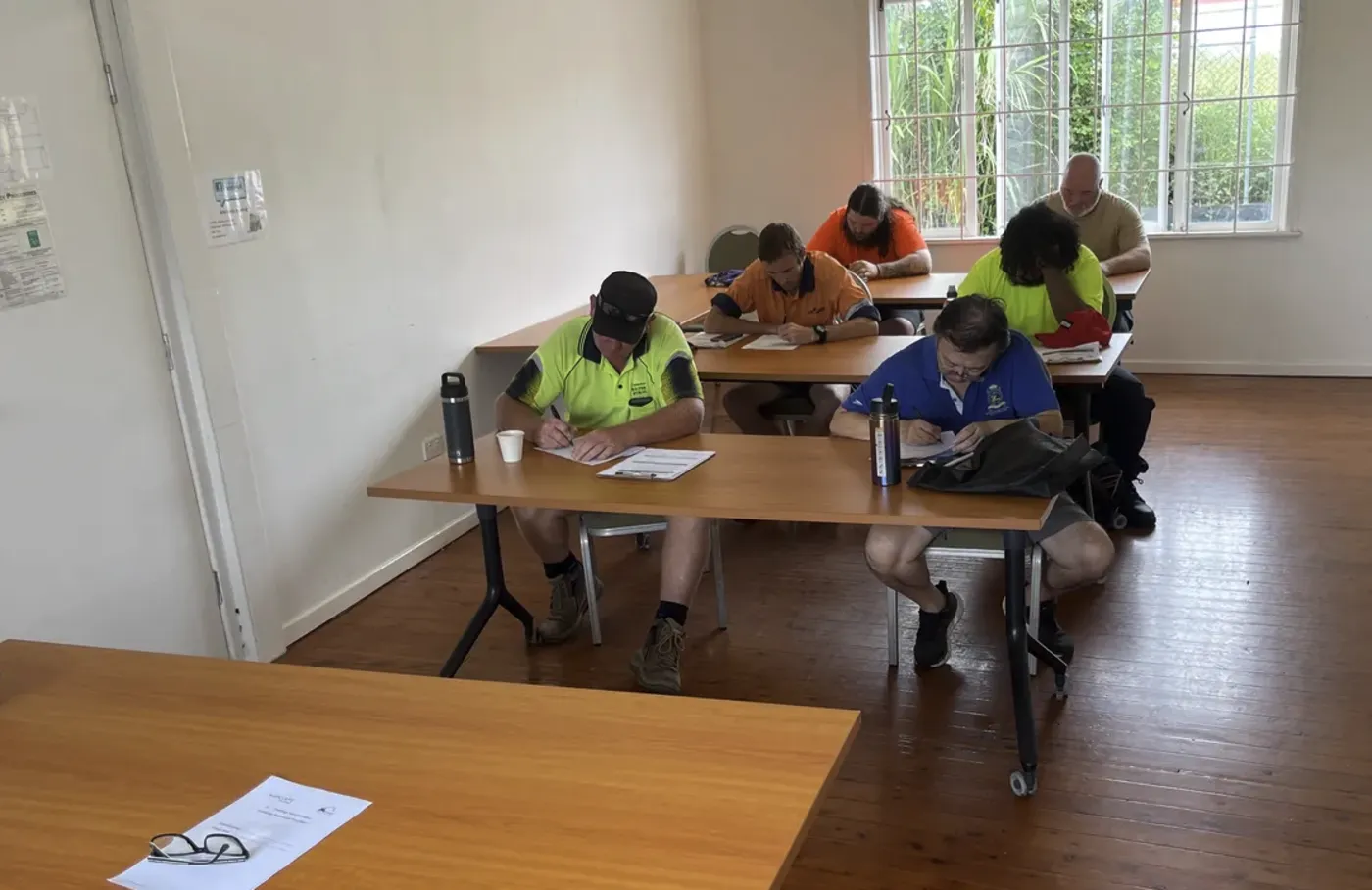 Students completing written assessment in the training room
